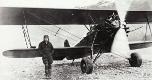 Merle &ldquo;Mudhole&rdquo; Smith in front of his Stearman C2B biplane NC 5415 in McCarthy, circa 1937. 